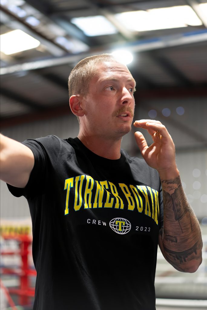 Adelaide Boxing Turner Gym A man with tattoos complete in a boxing ring.